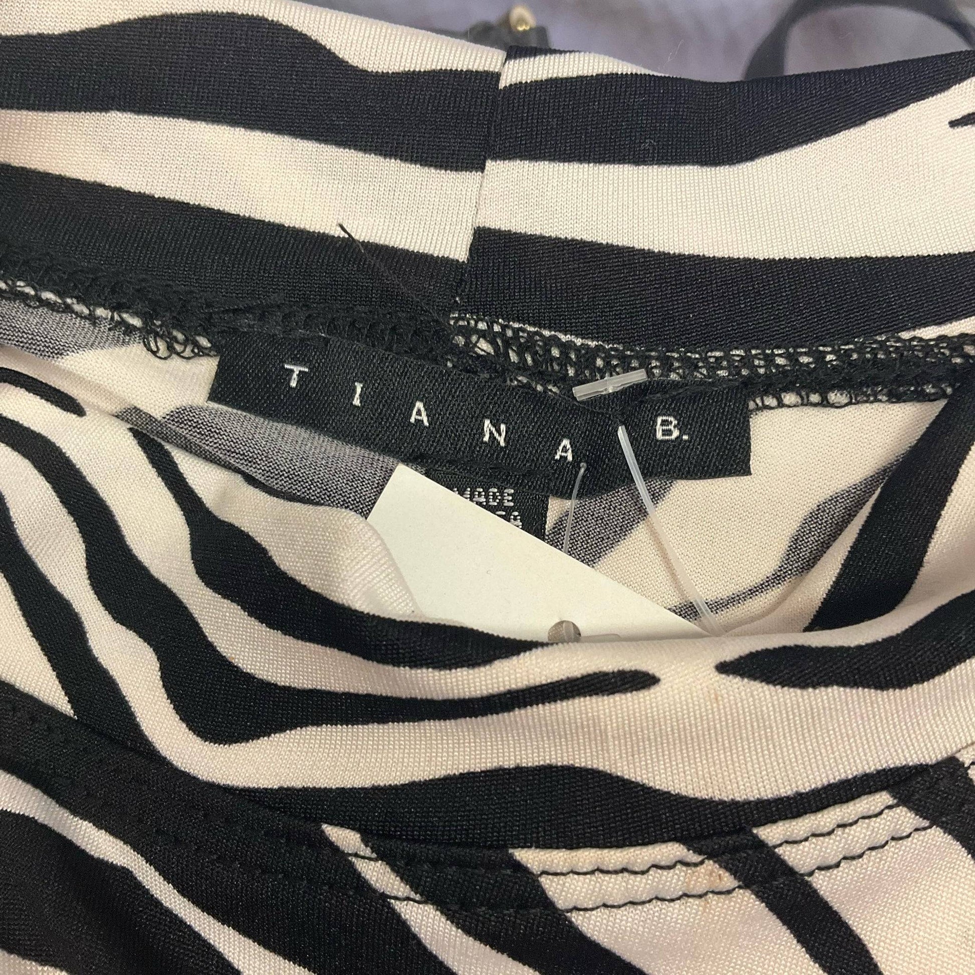 Close-up of Tiana B. brand label on zebra print dress, confirming authenticity for Margaret’s Fine Consignments listing.