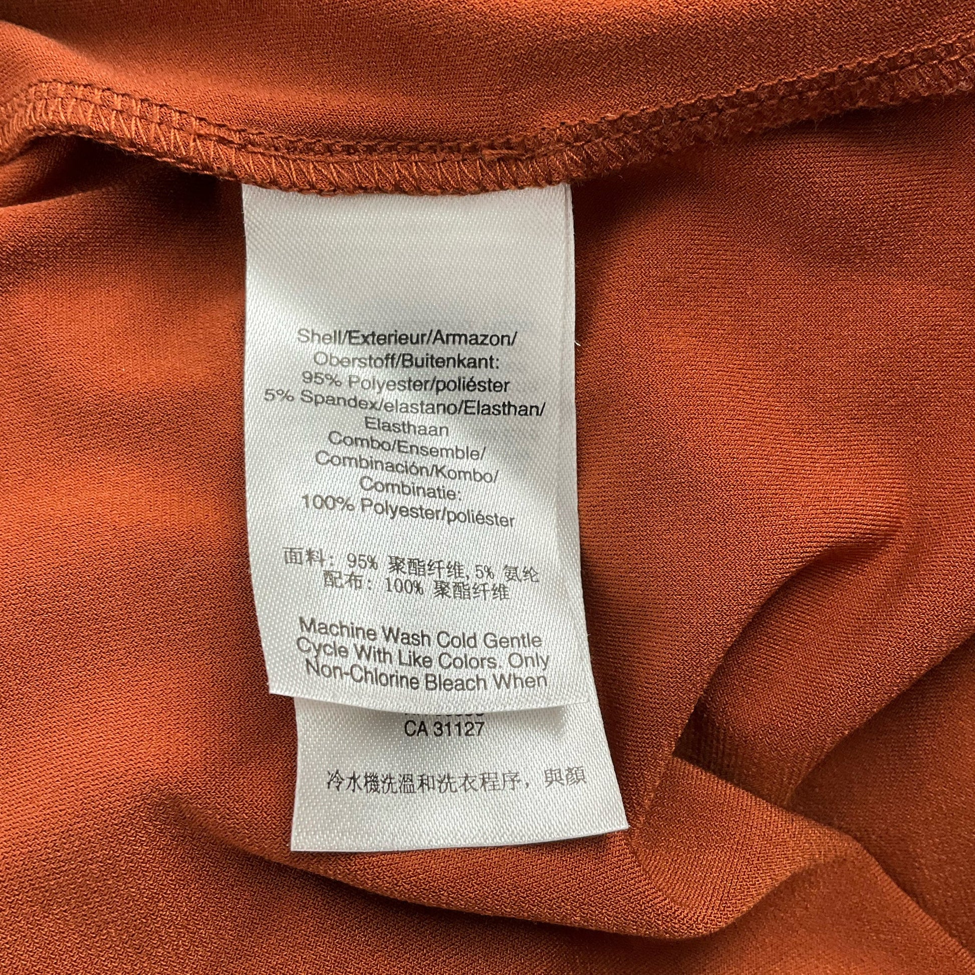 Fabric care label of DKNY Burnt Orange Pre-Owned Dress - Size XL, detailing polyester-spandex blend and washing instructions.