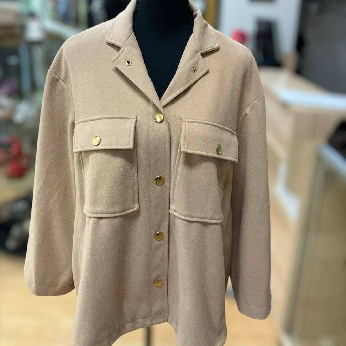 Tuckernuck Camel Solid Jacket - Size Medium with gold buttons and flap pockets, displayed on a mannequin in a boutique setting.