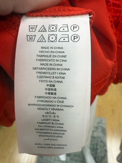Care label of Michael Kors red lace dress indicating washing instructions and made in China, suitable for sustainable fashion shoppers.