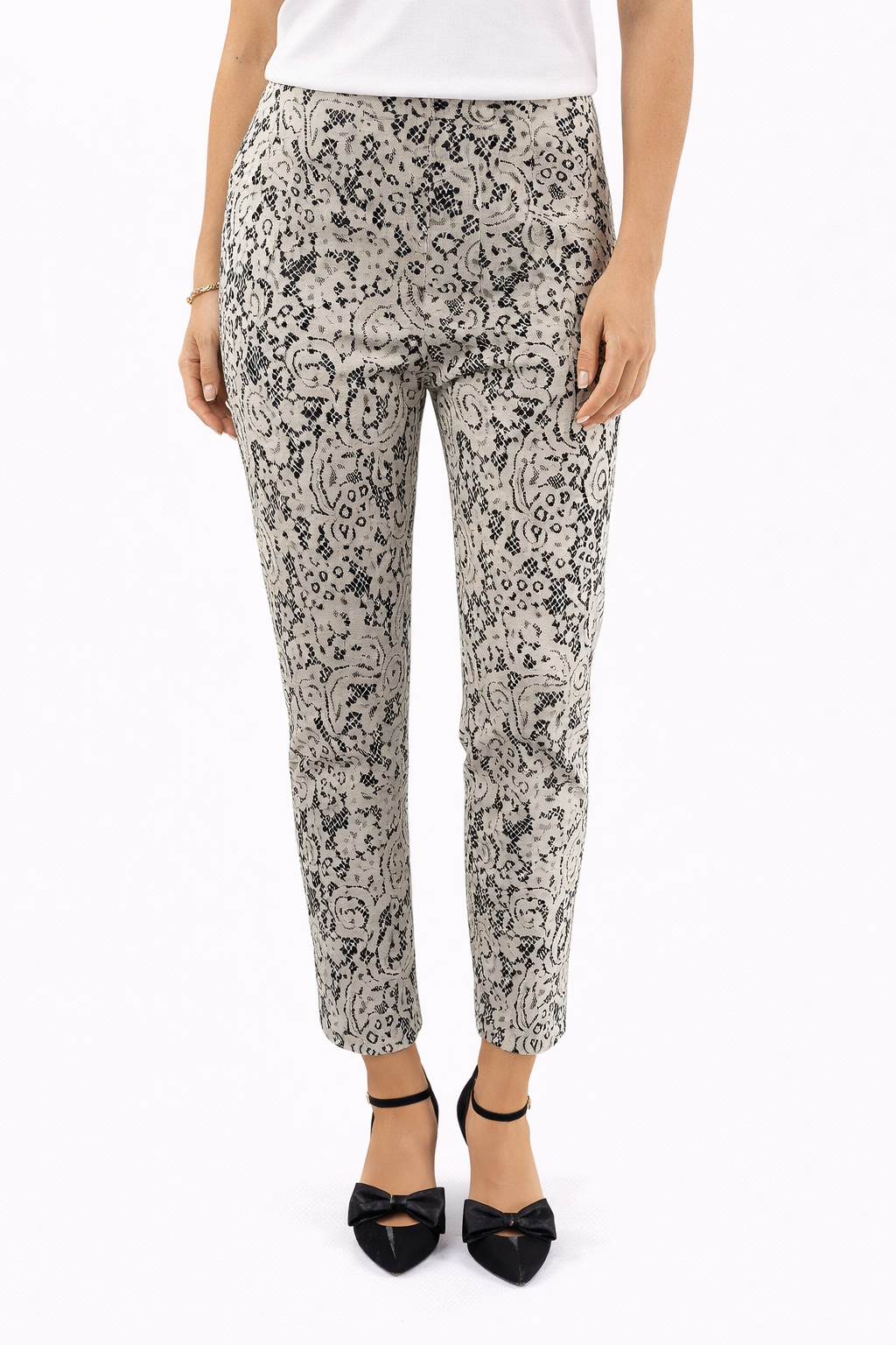 Chico's cream and black lace pull-on ankle pants, tapered leg, stretch knit, size small, displayed flat on a surface.