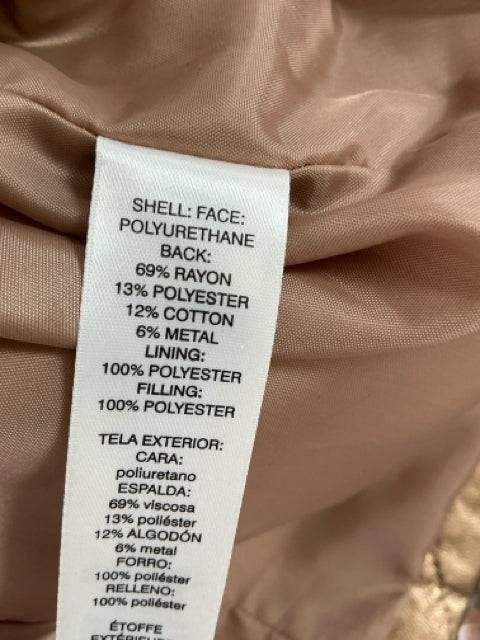 Close-up of fabric content label for Chico's gold quilted vest Size XL, showing material composition including rayon, polyester, and cotton.