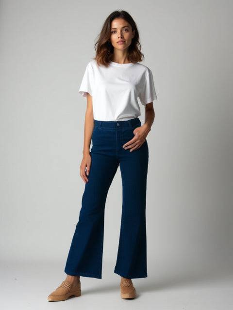 Model wearing Betabrand Jeans Size Small Long in dark blue, styled with a white tee and tan shoes, available at Margaret’s Fine Consignments.