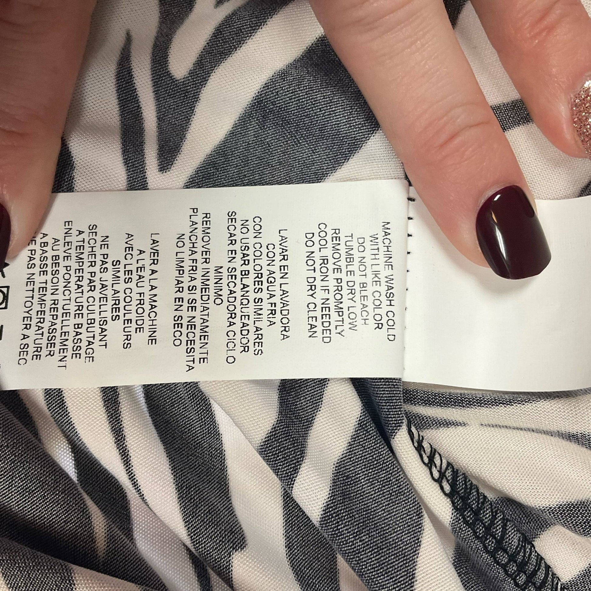 Care instruction label for Tiana B. zebra print dress, machine washable, size medium, available at Margaret’s Fine Consignments.