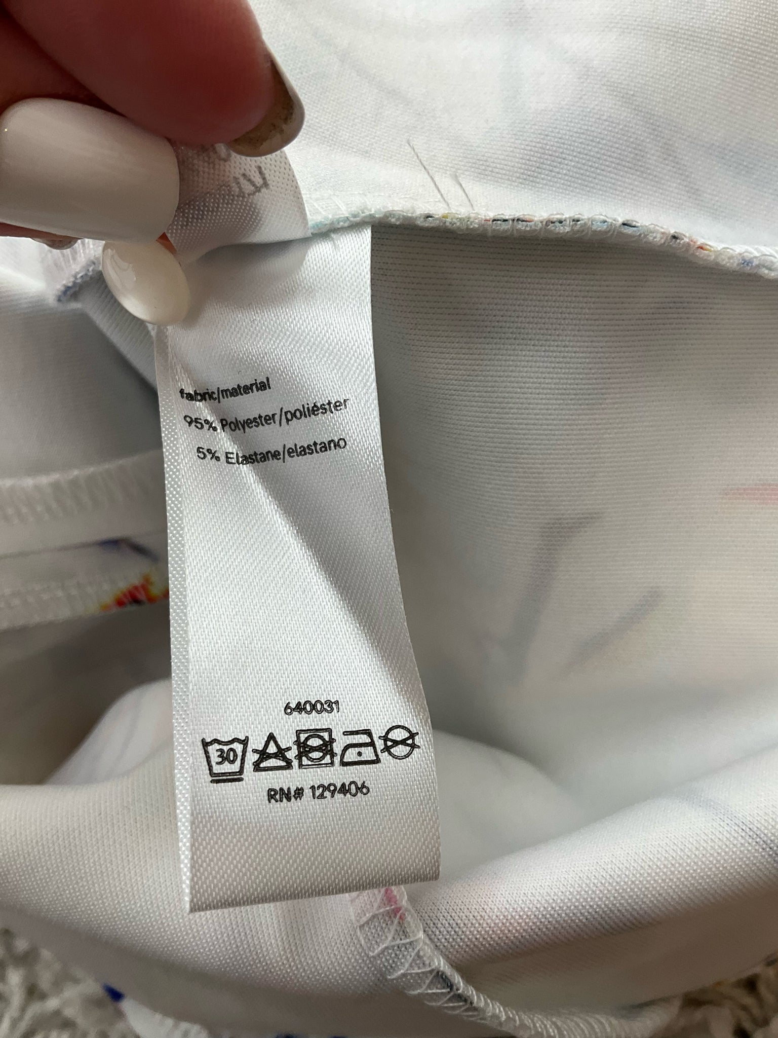 Fabric content tag of Venus dress showing 95% polyester and 5% elastane with RN# 129406, confirming material details.