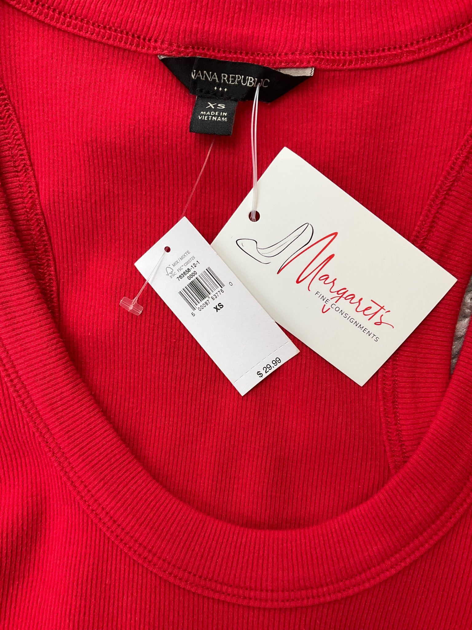 Close-up of Banana Republic red ribbed tank top neckline with original tags attached. Size XS, new with tags from Margaret’s Fine Consignments.
