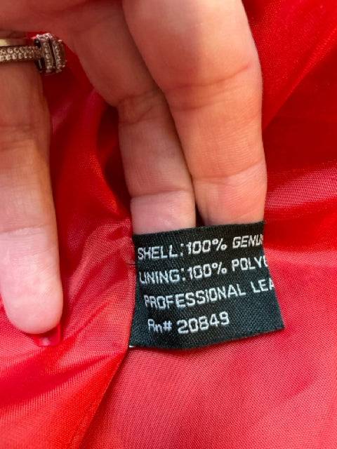 Close-up of Excelled Jacket label showing 100% genuine leather shell and polyester lining, care instructions included for leather cleaning.