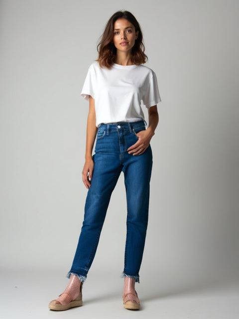 Model wearing Joes Jeans Size 6 in dark wash from Margaret's Fine Consignments. Pre-owned denim with a sleek, tapered fit and raw hem detail.