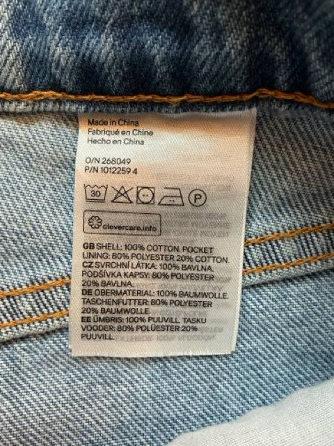 Close-up of care label on H&M Jeans Size 6 showing fabric composition and washing instructions. Available at Margaret’s Fine Consignments.