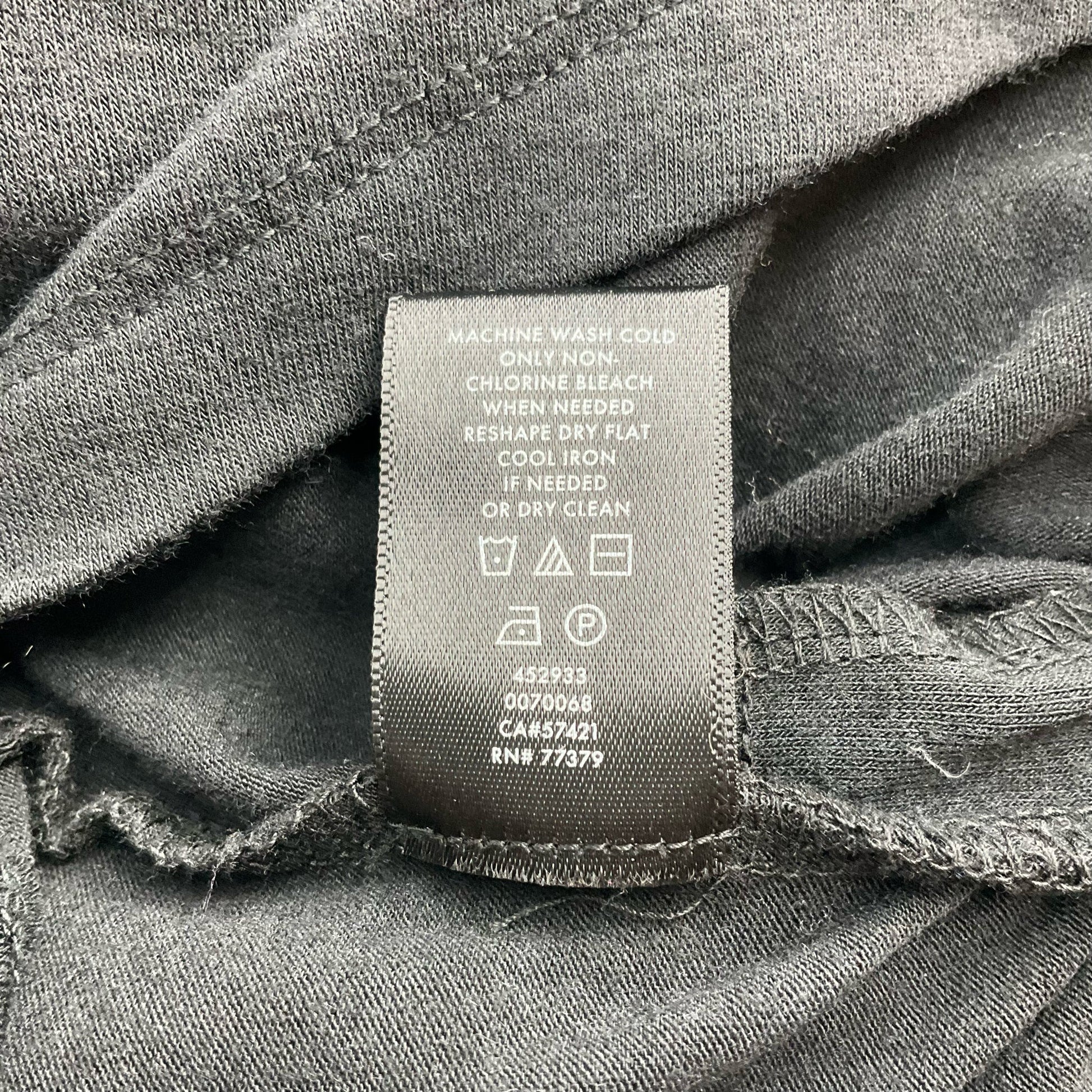 Care label of Ann Taylor Black Solid Pre-Owned Top - Size Small, detailing washing instructions and garment care symbols.