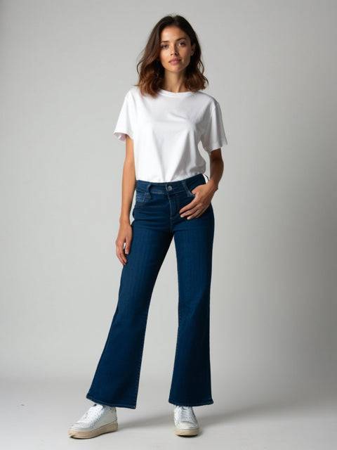 Model wearing Kut Jeans Size 0 in dark blue boot cut style, showcasing classic fit and retro comfort for casual wear.