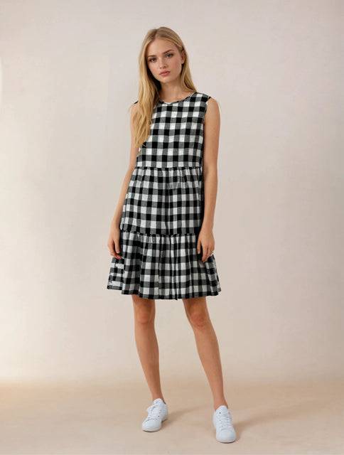 This & That Dress Size Small in black and white checkered pattern, sleeveless with tiered skirt, styled casually with white sneakers.