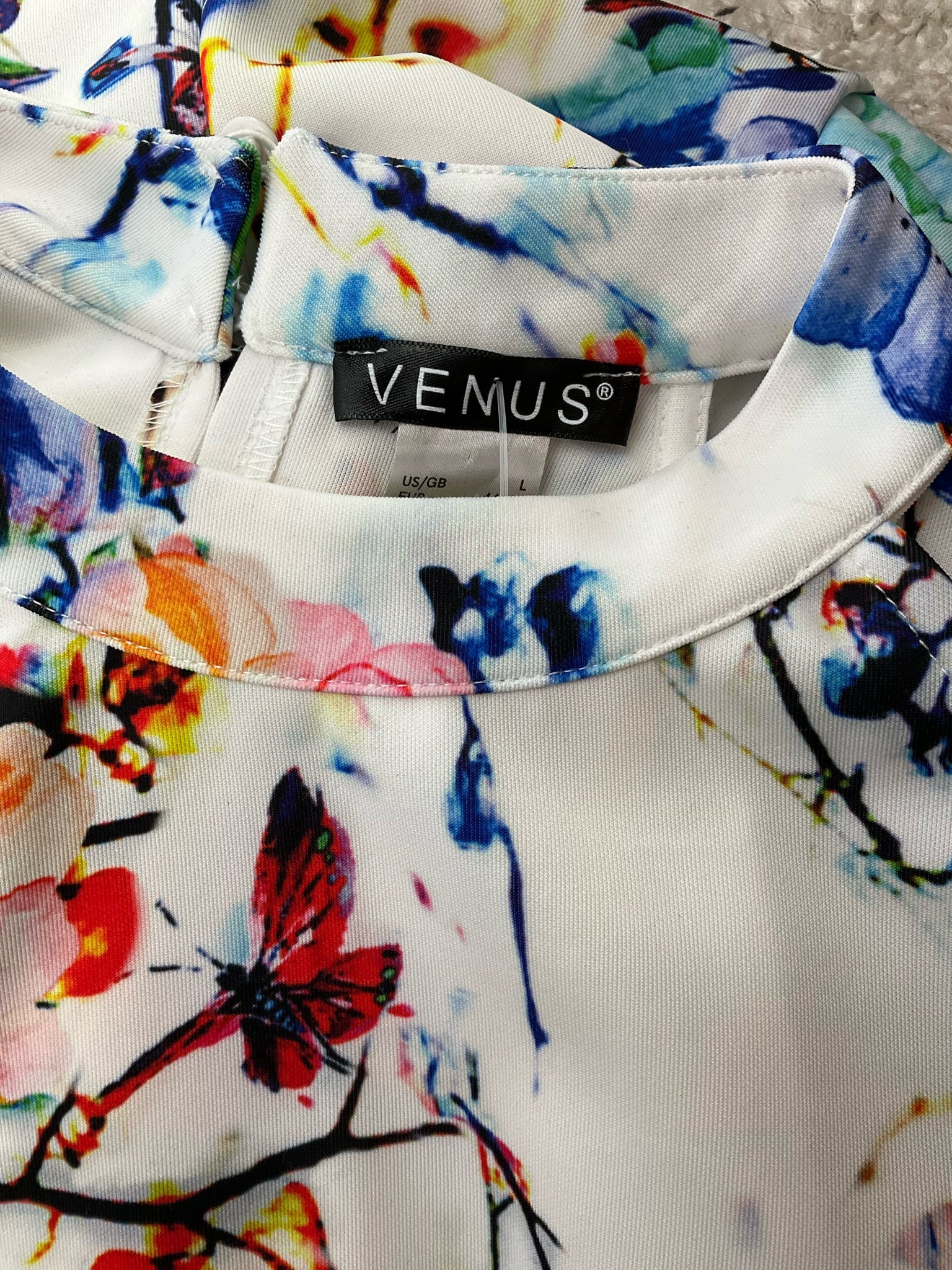 Close-up of Venus brand label on the white floral halter dress, confirming size US/GB L and original branding.