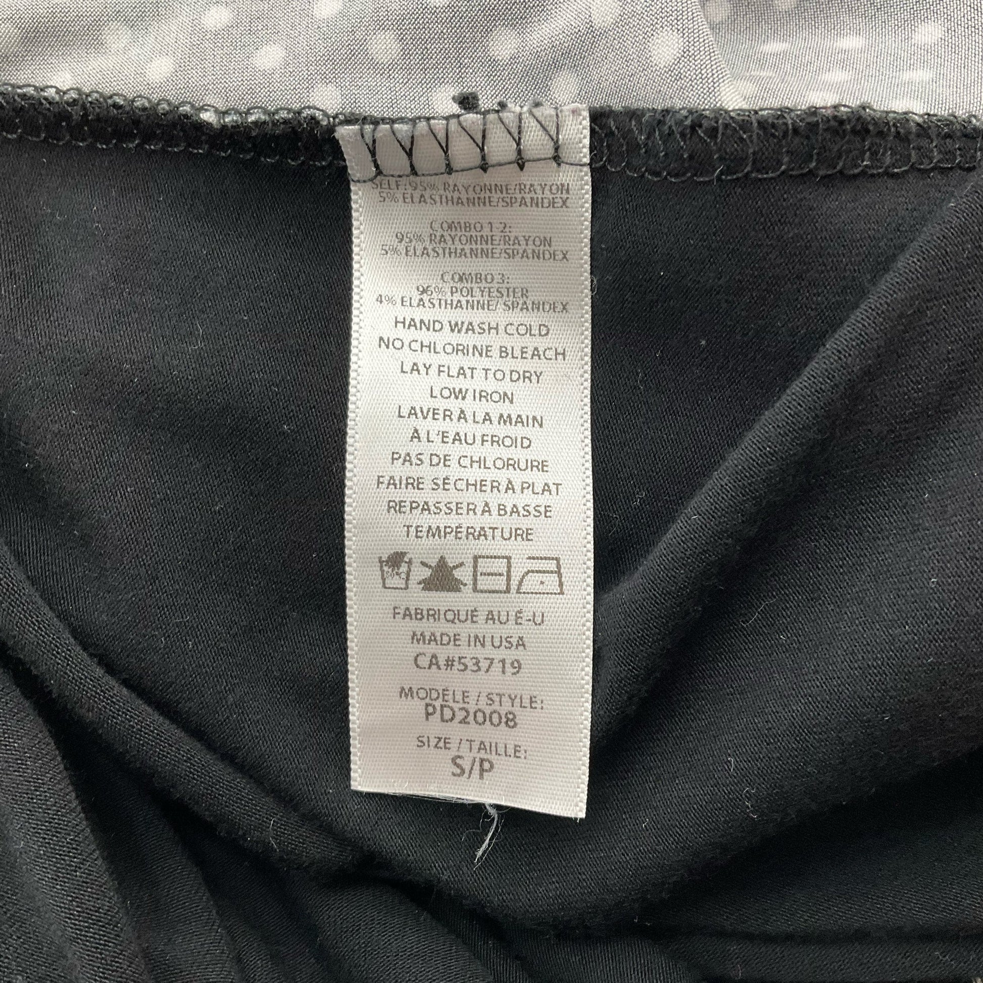 Garment care label of Cielo Blu red/black top, size small, showing fabric composition and washing instructions for consignment apparel.