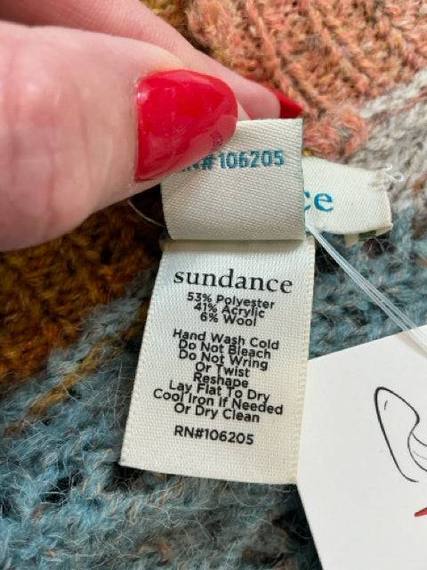 Close-up of Sundance Shrug Size XS/S fabric tag showing material blend and care instructions. Find this sustainable piece at Margaret’s Fine Consignments.