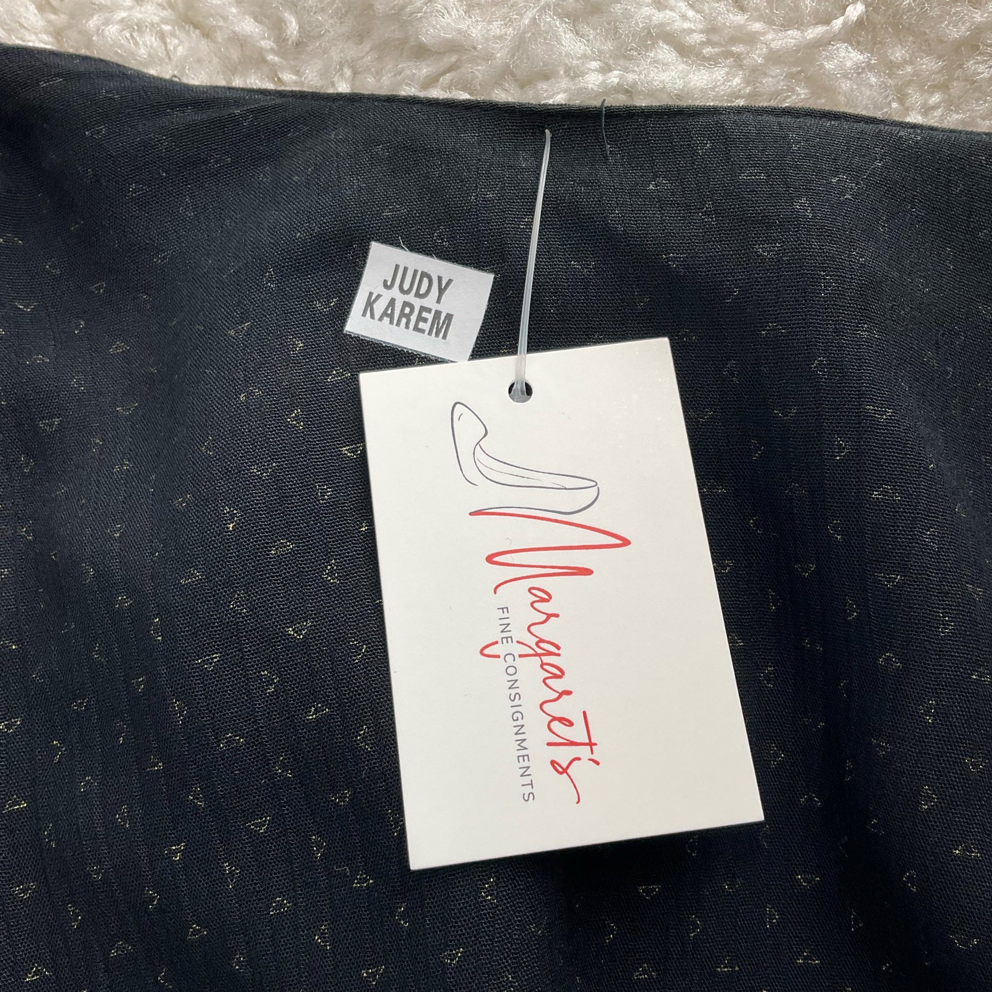 Close-up of interior label and tag on pre-owned colorful printed shrug by Judy Karem, sold by Margaret's Fine Consignments.