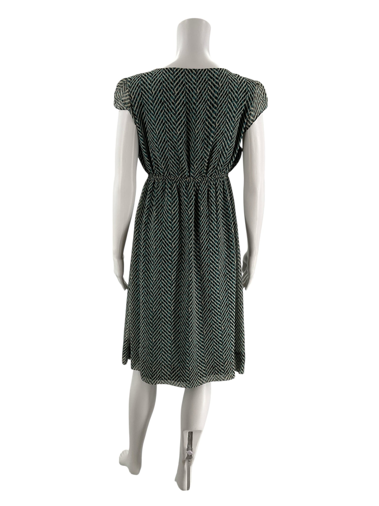 Back view of New York & Co teal and cream empire waist dress, showing herringbone pattern and gathered waist detail on mannequin.