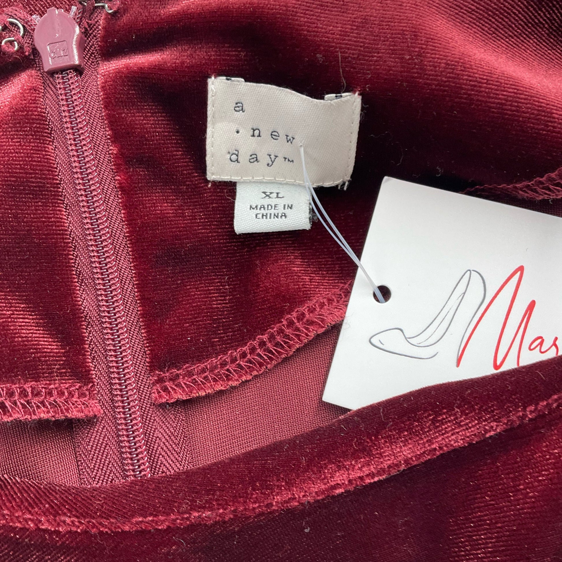 Close-up of A New Day brand label and size tag on Burgundy Pre-Owned Dress - Size XL, confirming authenticity and condition.