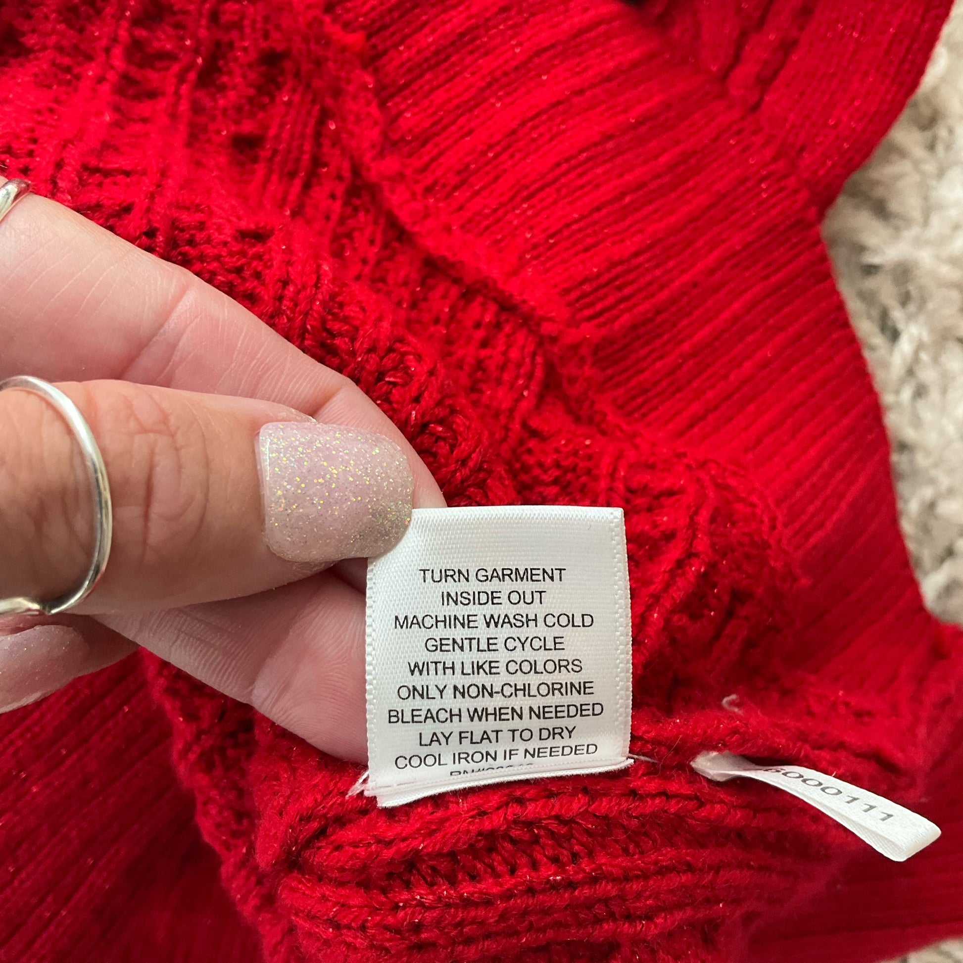 Care label on New York & Co red sweater top, size small, with washing instructions for maintaining quality in women’s consignment clothing.