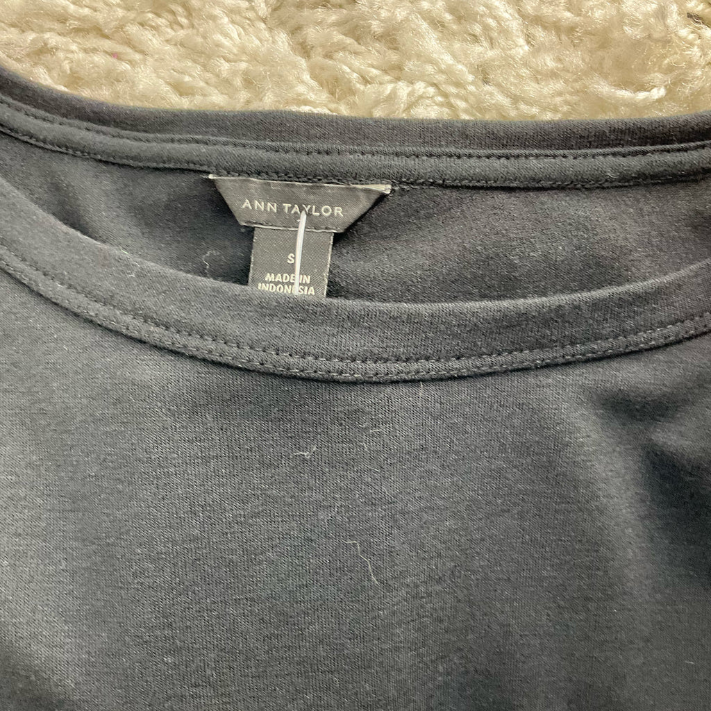 Close-up of Ann Taylor brand label on Black Solid Pre-Owned Top - Size Small, confirming size and origin as Made in Indonesia.
