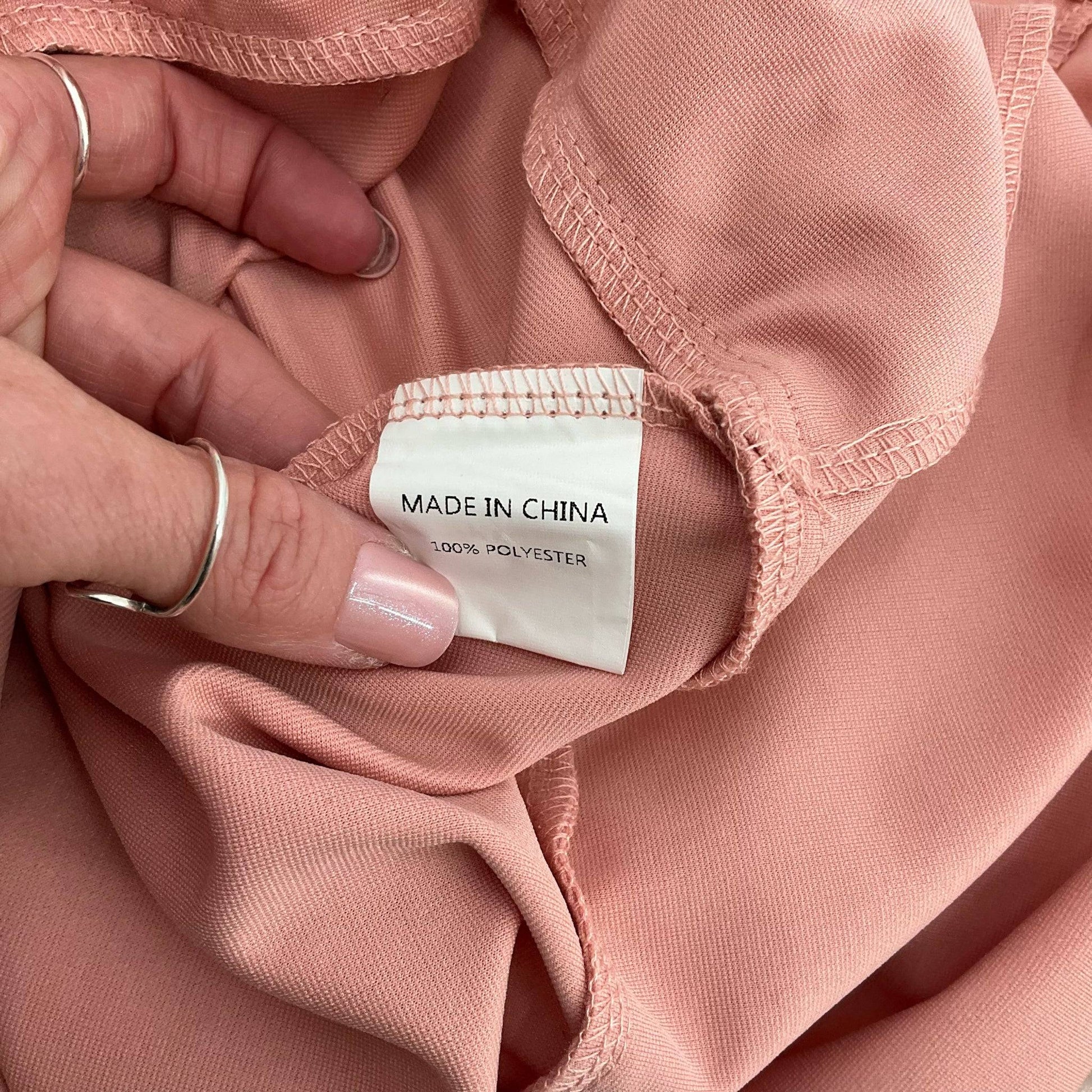 Fabric content tag showing 100% polyester material on Simplee Dress Size Large, offered by Margaret’s Fine Consignments.