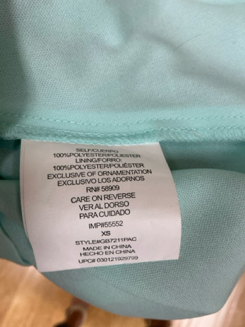 Close-up of fabric tag on GB Aqua/Yellow/Black Animal Pre-Owned Ladies Dress - Size XS showing 100% polyester material and care instructions.