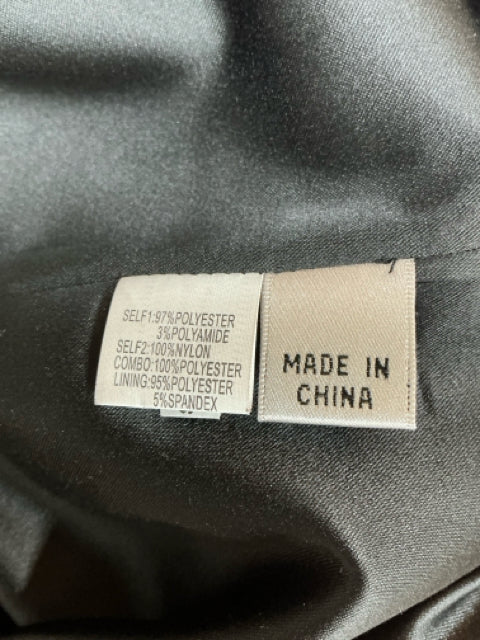 Close-up of fabric content label showing polyester, nylon, and spandex blend for Kay Unger black floral brocade dress, made in China.