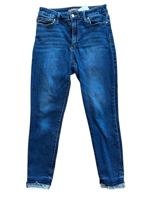 Flat lay of Joes Jeans Size 6 in dark wash from Margaret's Fine Consignments. Features solid color, classic five-pocket style, and frayed hems.