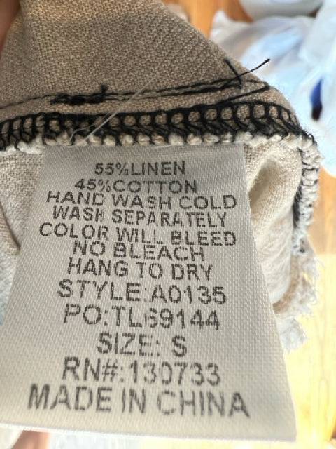 Close-up of fabric tag on Umgee Dress Size Small showing linen-cotton blend and care instructions, available at Margaret's Fine Consignments.