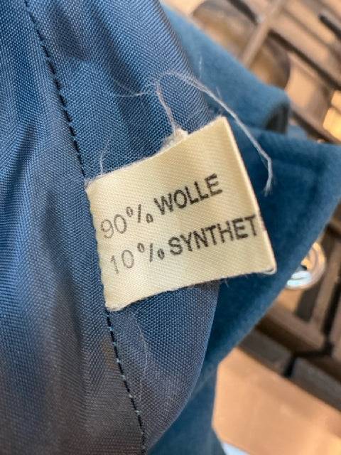 Close-up of fabric tag on Gil Bret Cape Size 2X/3X, showing 90% wool and 10% synthetic blend. High-quality material from Margaret’s Fine Consignments.