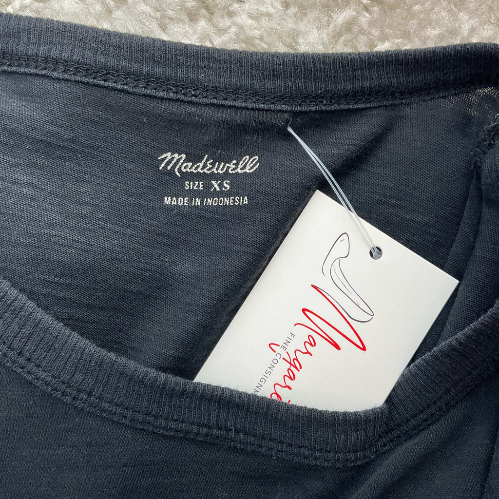 Close-up of Madewell blouse label showing size XS and tag, confirming authenticity and pre-owned condition.