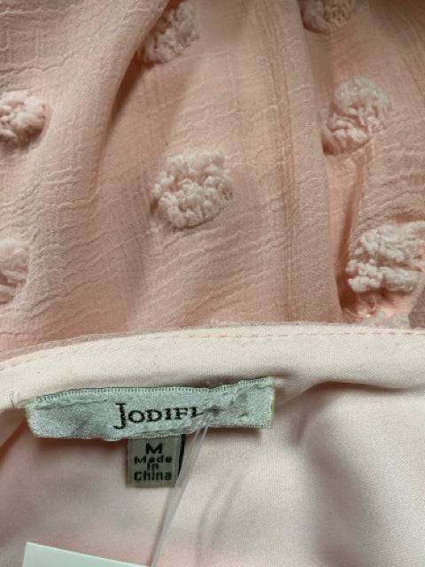 Close-up of Jodifl dress label showing size Medium and blush Swiss dots texture, available at Margaret’s Fine Consignments.