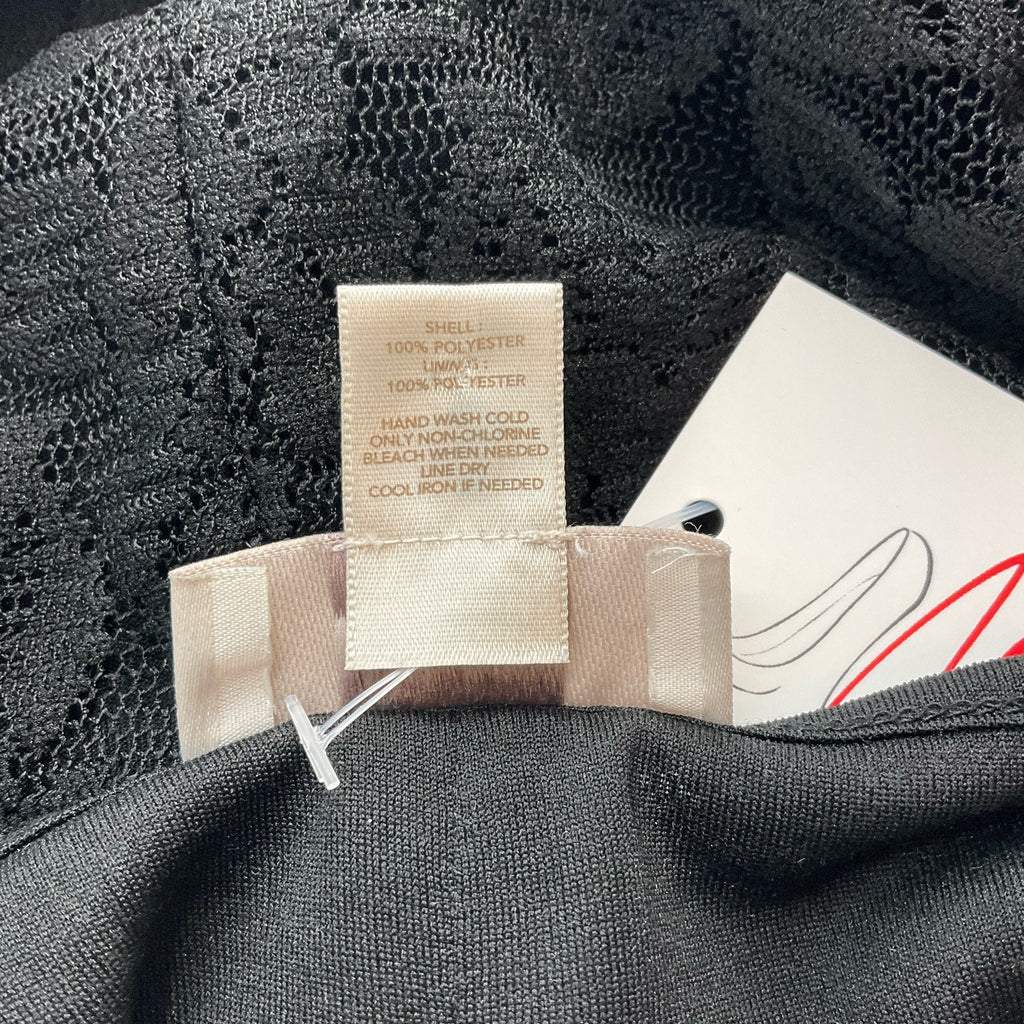 Fabric care label of Loft Black Lace Pre-Owned Top - Size Small showing 100% polyester composition and washing instructions.