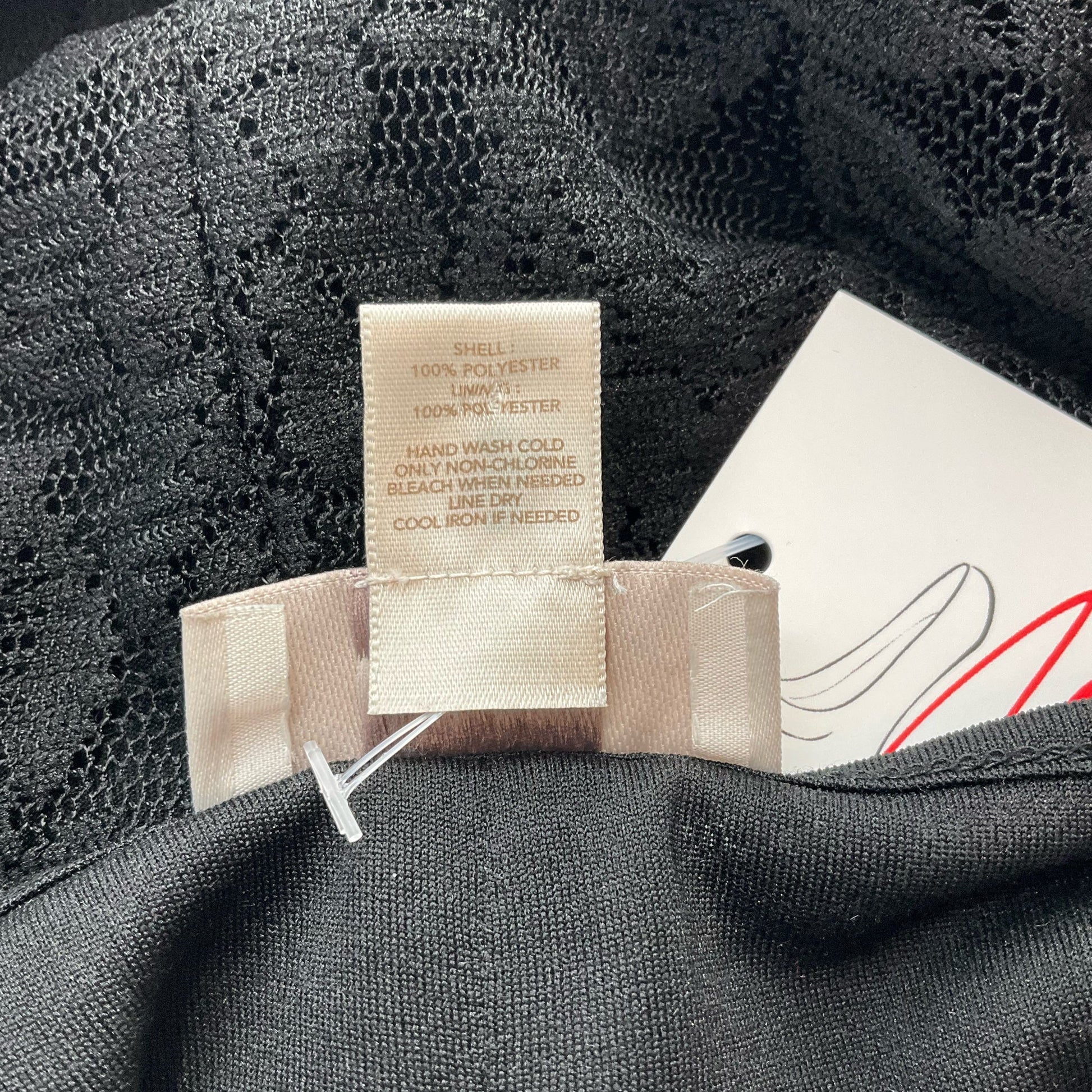 Fabric care label of Loft Black Lace Pre-Owned Top - Size Small showing 100% polyester composition and washing instructions.