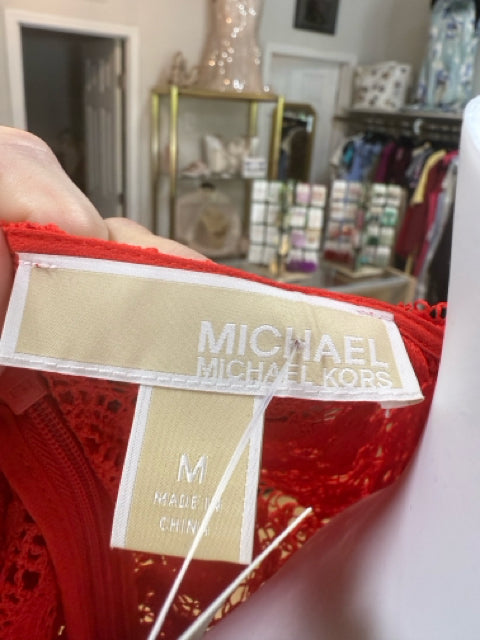 Brand label of Michael Kors red lace dress in size medium, confirming authenticity of this pre-owned designer party dress.