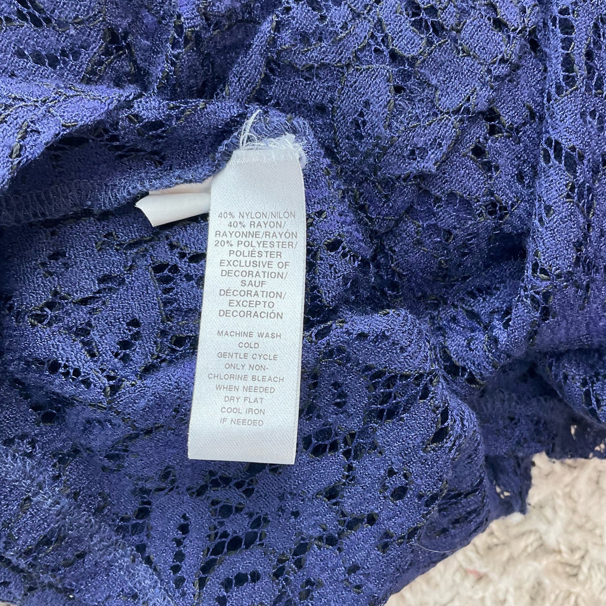 Fabric care label of Loft Blue Lace Pre-Owned Top - Size M showing nylon, rayon, and polyester blend with machine wash instructions.