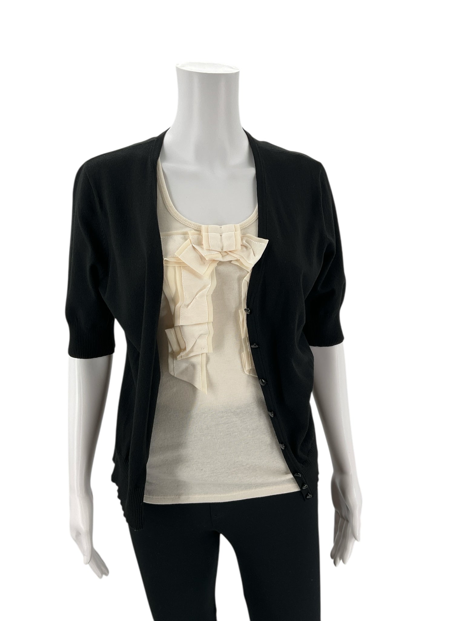 Women's Ann Taylor black shrug worn open over a cream ruffle top, showcasing its versatile layering style for polished everyday looks.