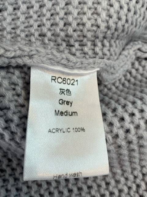 Close-up of fabric tag on No Brand Shrug Size Medium showing 100% acrylic material and gray color, confirming product details for resale.