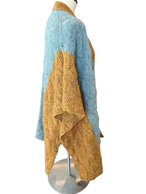 Side view of Sundance Shrug Size XS/S on mannequin, emphasizing mustard and blue knit sections. Shop this cozy layering piece at Margaret’s Fine Consignments.