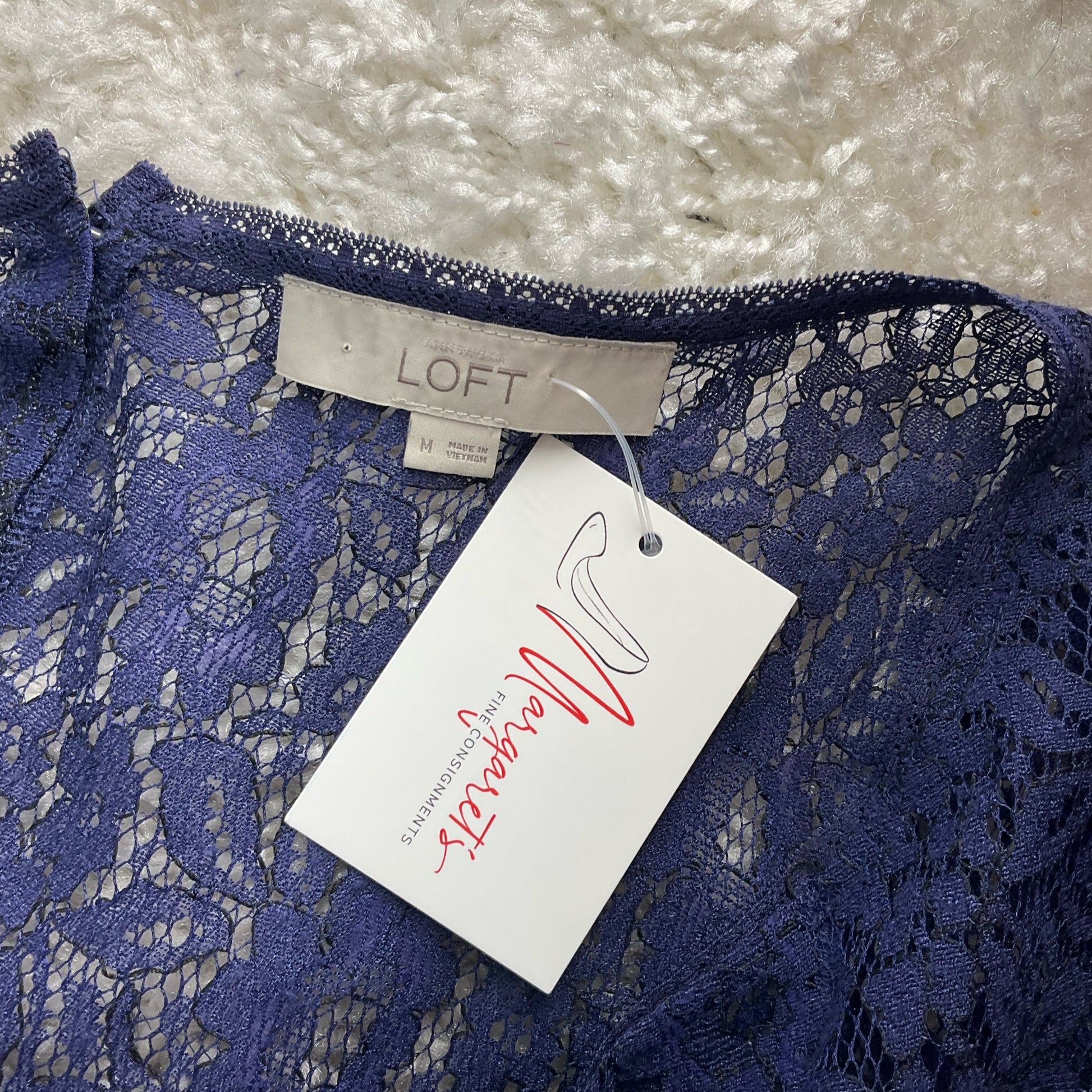 Close-up of Loft brand label and attached tag on Blue Lace Pre-Owned Top - Size M, confirming authenticity and medium sizing.