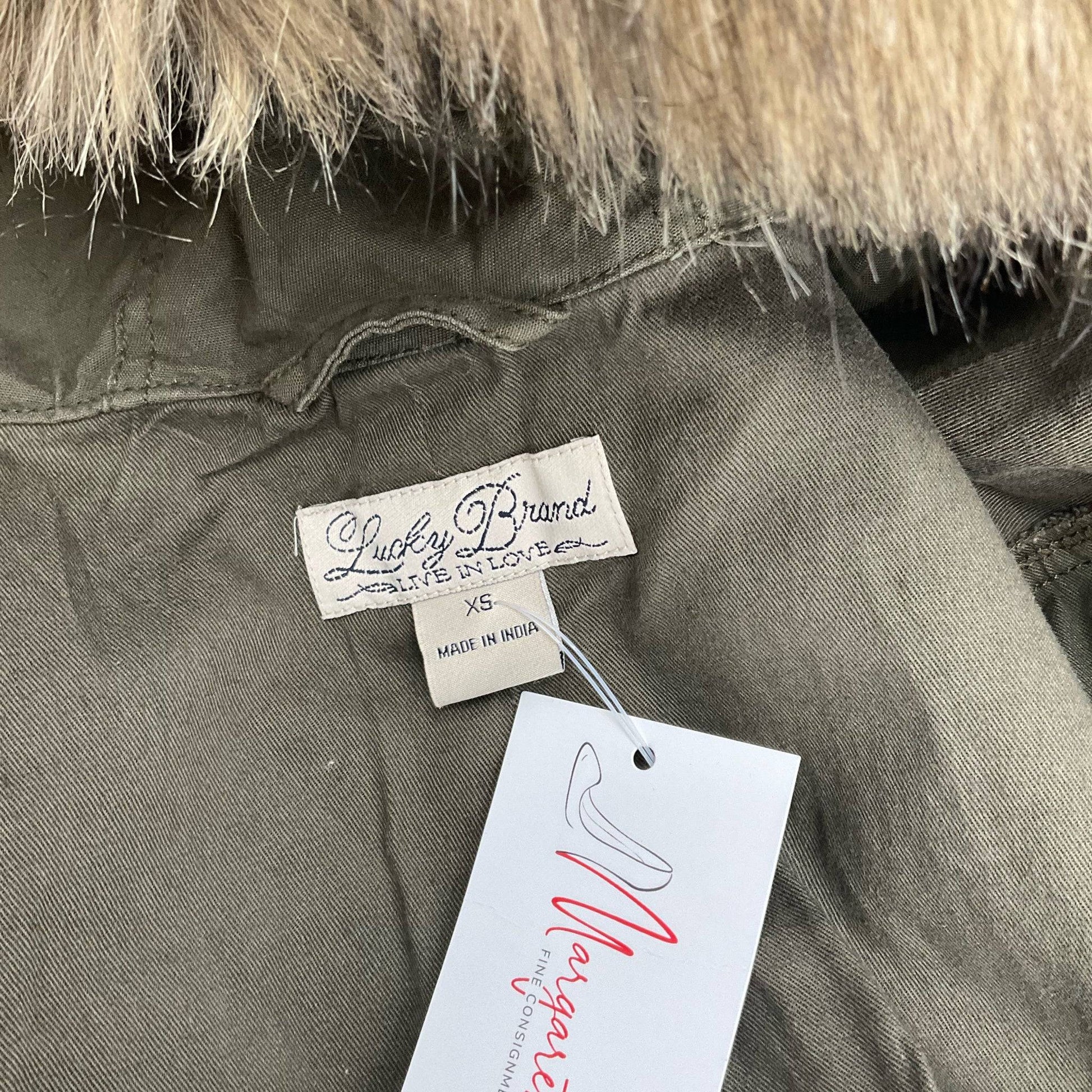 Close-up of Lucky Brand label on Olive Solid Jacket – Size XS, highlighting brand authenticity and Margaret’s Fine Consignment tag.