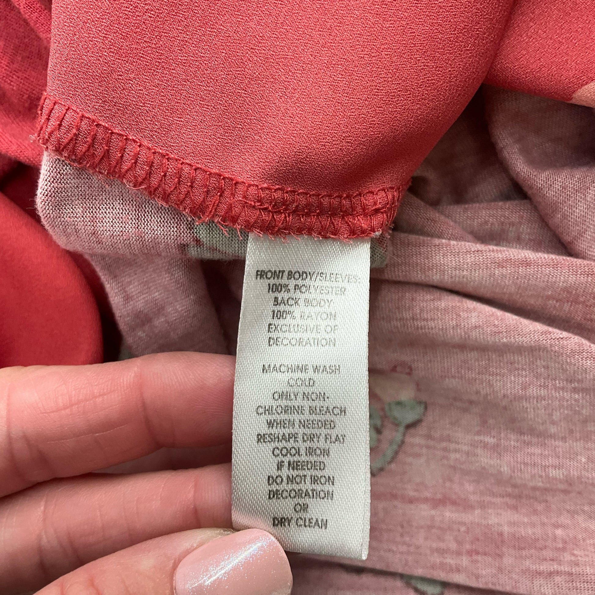 Fabric care label of Loft red floral blouse, detailing polyester and rayon blend, machine washable, size small, pre-owned.